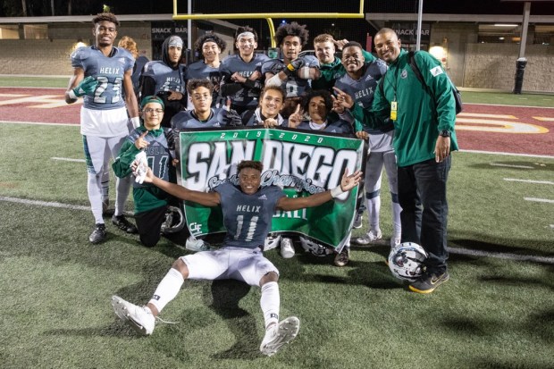 Helix High School defensive back Keionte Scott, seated, celebrates with his teammates after winning the CIF San Diego Section championship. (Damaja Jones)
