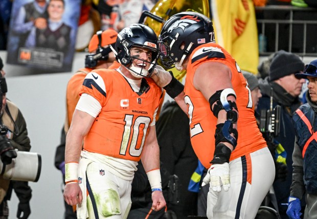 Bo Nix (10) of the Denver Broncos celebrates with Garett Bolles (72) after throwing a touchdown to Marvin Mims Jr. (19) during the fourth quarter of the Broncos' 33-30 overtime win over the Buffalo Bills at Empower Field at Mile High in Denver on Saturday, Jan. 17, 2026. (Photo by AAron Ontiveroz/The Denver Post)
