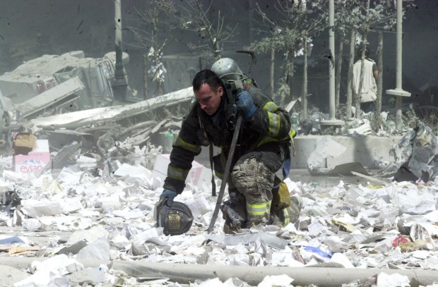 A firefighter kneels in the rubble of the World Trade Center after it was destroyed by planes in a terrorist attack on Sept. 11, 2001. (Todd Maisel / New York Daily News)