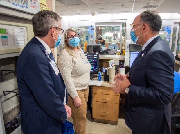 Jennifer Lewis, an ED crisis clinician, center, talks with Adam Steinberg, Hartford HealthCare vice president of medical affairs, left, and Jeff Flaks, Hartford HealthCare president and CEO, as Manchester Memorial Hospital and the Rockville campus officially join Hartford HealthCare on Monday, Jan. 5, 2026. (Aaron Flaum/Hartford Courant)