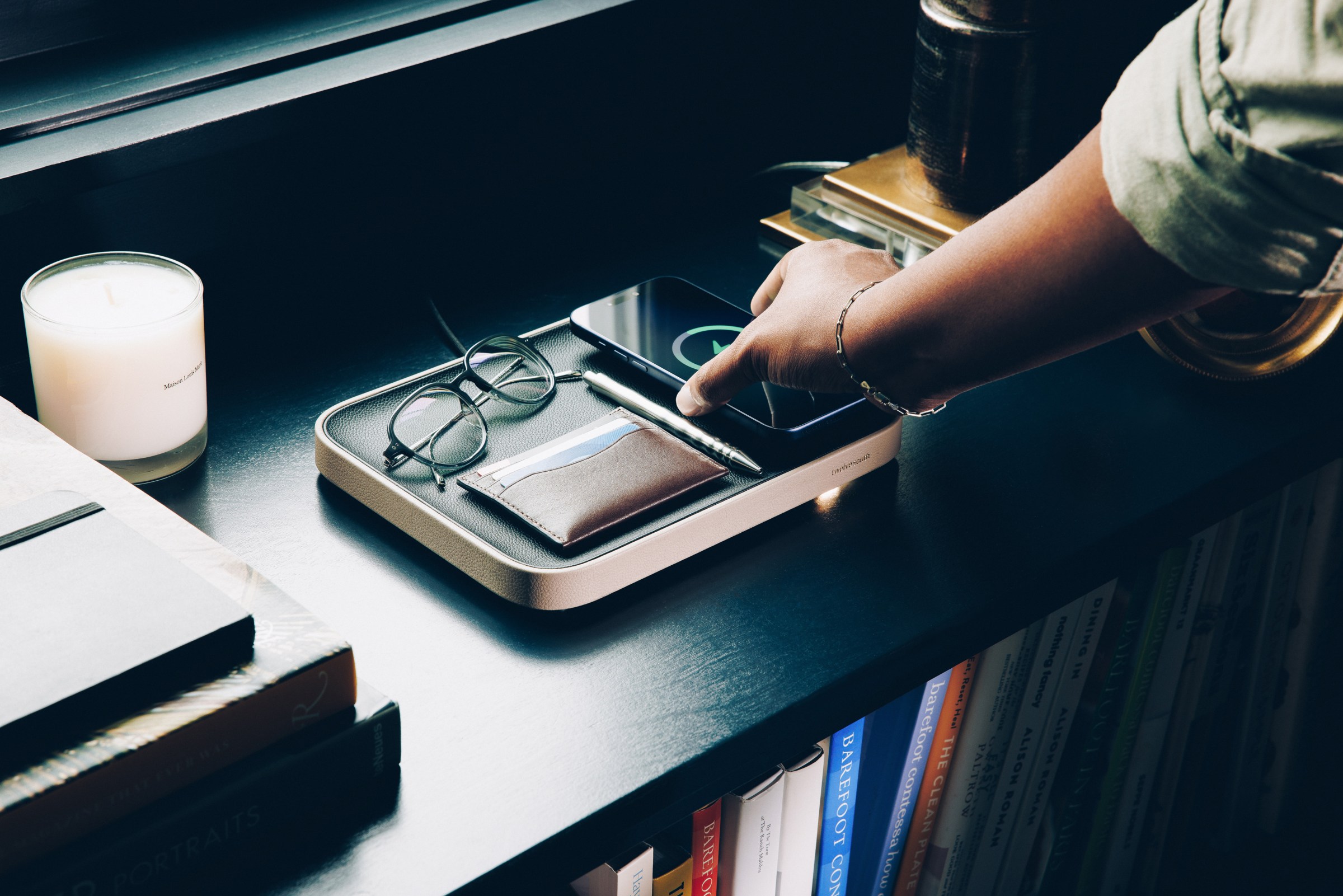 A photo of a charging tray, with several devices in it, on a table.