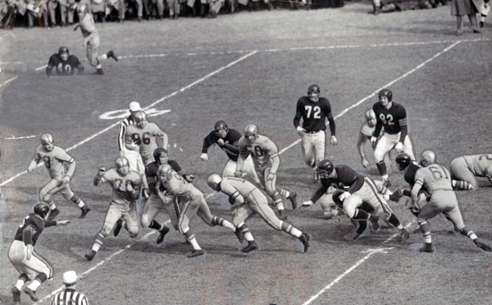 Green Bay Packers quarterback Tobin Rote rushes for a seven-yard gain against the Chicago Bears at Wrigley Field on November 9, 1952. The Packers won the game 41-28.