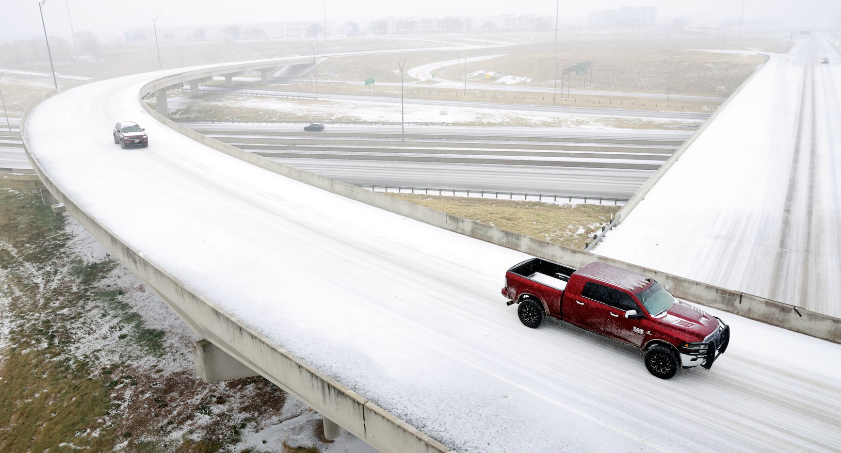 Drivers navigate the sleet covered overpasses around SH 360 at SH 183 in Fort Worth, January...