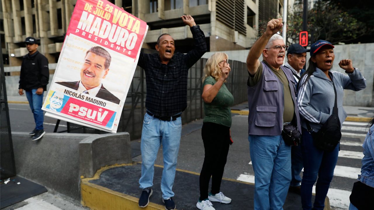 Supporters display a poster of Venezuelan President Nicolás Maduro in Caracas, Venezuela, Saturday, Jan. 3, 2026, after U.S. President Donald Trump announced Maduro had been captured and flown out of the country. (AP Photo/Cristian Hernandez)