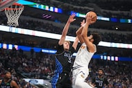 Denver Nuggets guard Jamal Murray, right, goes up for a basket against Dallas Mavericks...