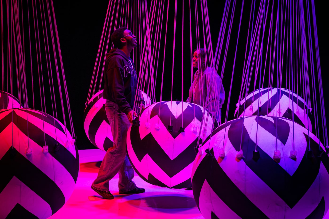 Mahlet Mamo, of Dallas, and Carlton Kigonya, of Richmond, walk around the “Swing” exhibit at...
