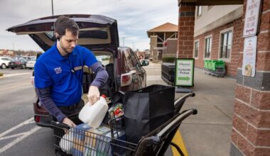 Wegmans employee Erik Van Slaars loads an online order into a customer's vehicle in the curbside pickup area outside the Mount Laurel store.