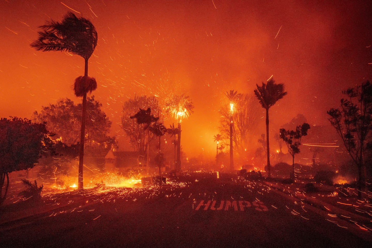 Embers blew down a street as the Palisades Fire ravaged a neighborhood in the Pacific Palisades neighborhood of Los Angeles, on Jan. 7, 2025.