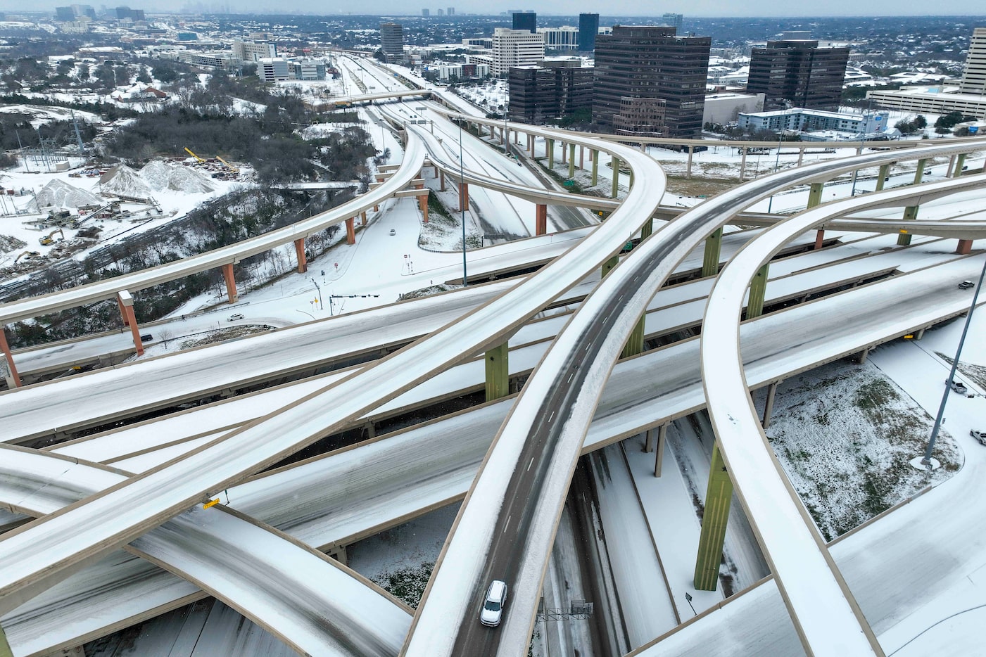 Motorists navigate an icy mix covering the High Five Interchange at US 75 and I-635 during a...
