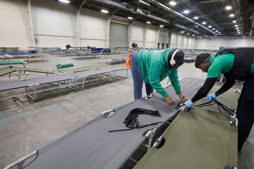 OurCalling staffers Fahdel Scriven and security officer Daniel Williams set up stretchers at...