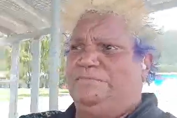 Valmae walks along a pier in relatively calm weather on Palm Island.  
