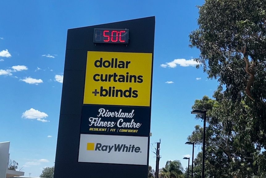 50C displayed on an electric sign also showing logos of a curtain retailer, a gym and a RayWhite office