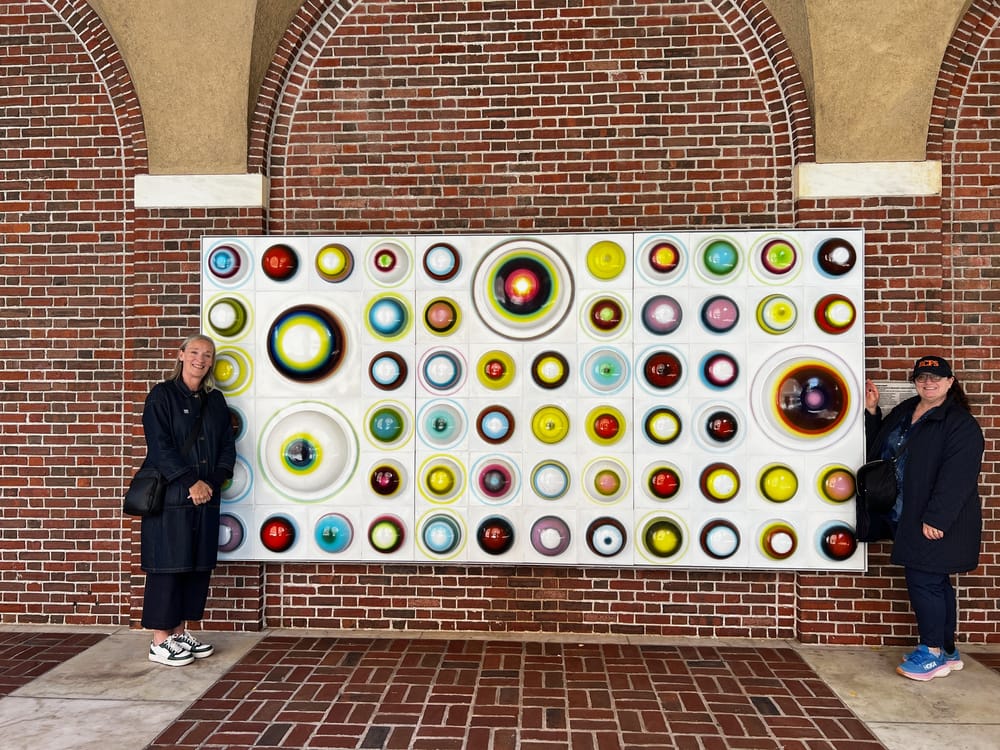 The author Jo Holmes (left) and Richard's daughter, Robyn Roth-Moise (right), posing with Knapp's work at the Museum of the City of New York