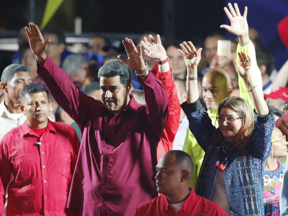 Venezuela's President Nicolas Maduro and his wife Cilia Flores wave to supporters at the presidential palace in Caracas on Sunday after election officials declared his victory