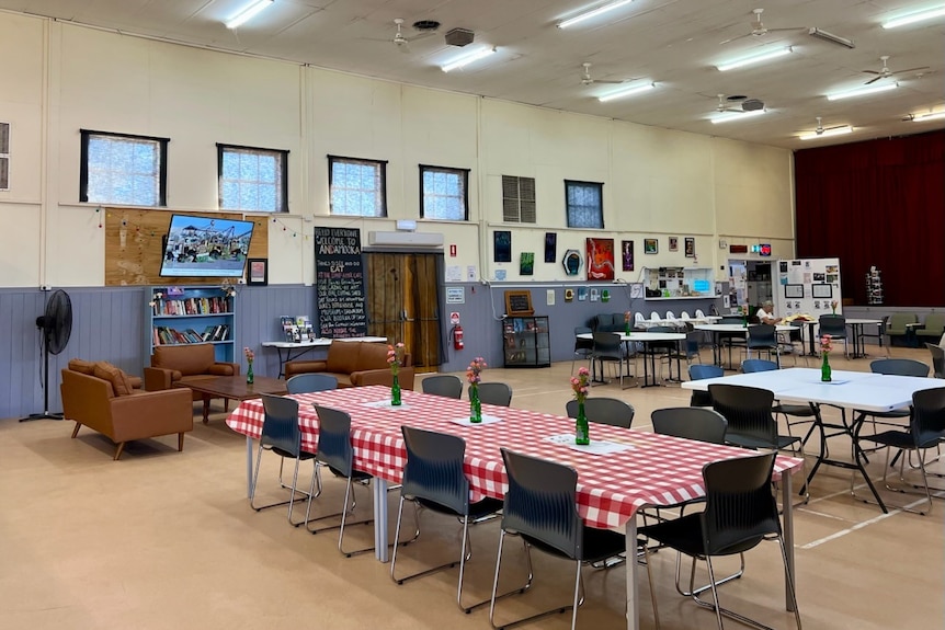 The inside of a town hall with a two tables and sofas in the background.