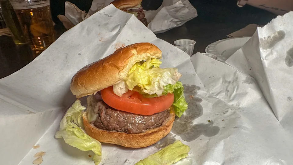 Burger on parchment paper with lettuce and tomato