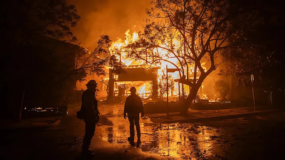 Firefighters watch Palisades Fire consume a home