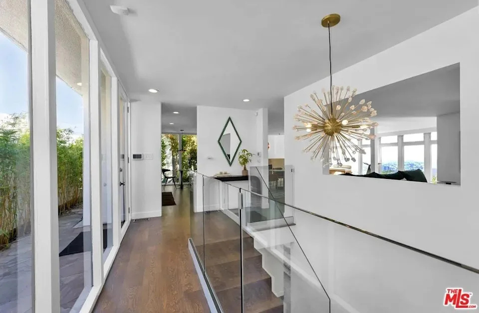 The main entry and living space are on the first level, and the rest of the home dramatically cascades down the hill in back, taking full advantage of the terraced lot and views.