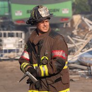 Lieutenant Kelly Severide holding an axe dressed in a firefighter uniform on Chicago Fire Season 14 Episode 2.