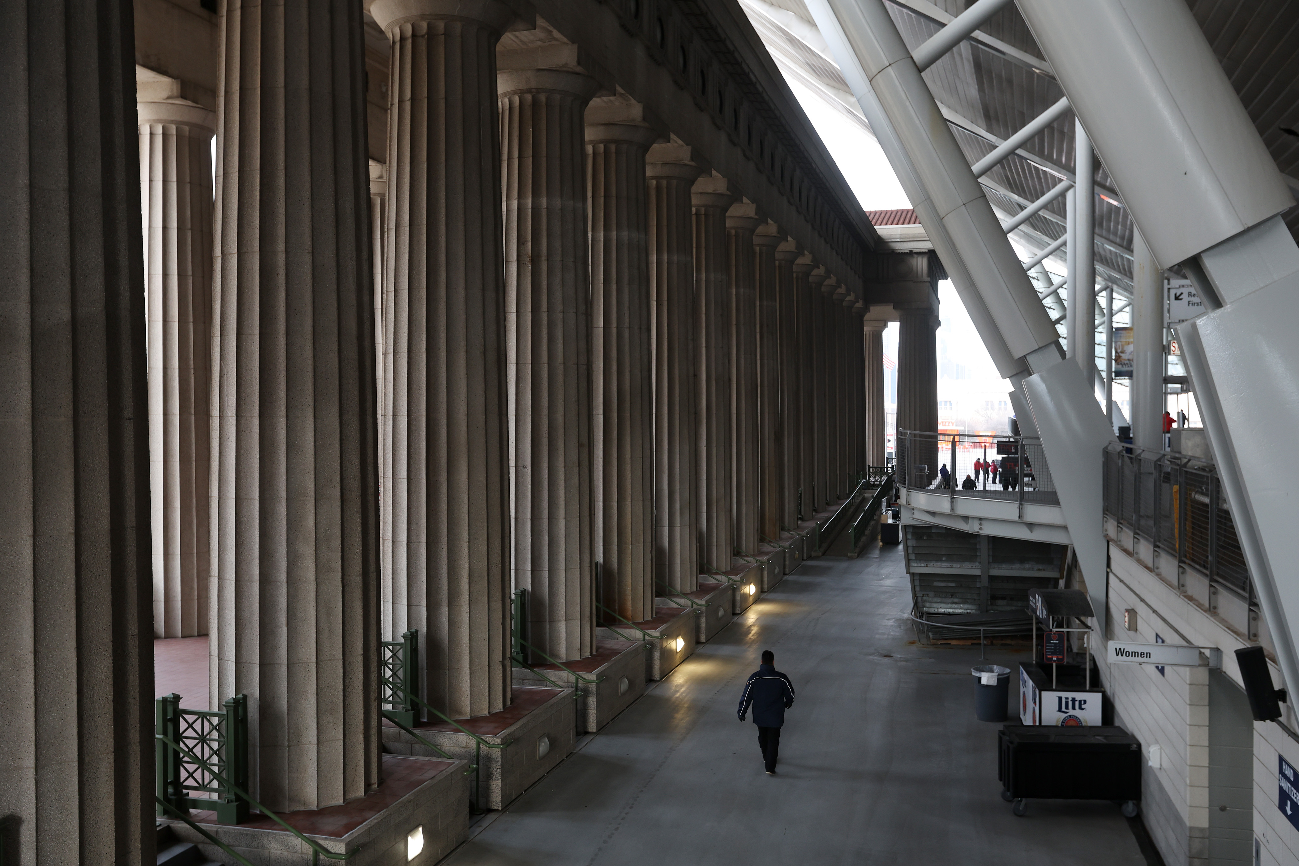 A worker walks past the west colonnade before a game...