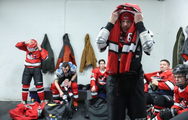 Zack Dessent puts on his sweater while suiting up with teammates of the Chicago Pride Hockey team for a game against the Chicago Aces at the American Heartland Ice Arena, Jan. 15, 2026, in Lincolnwood. (John J. Kim/Chicago Tribune)