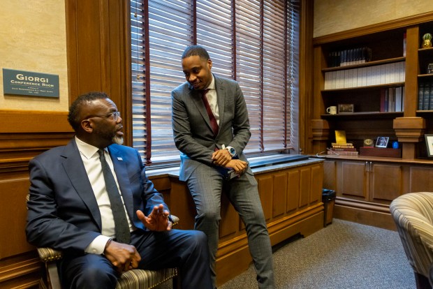 Mayor Brandon Johnson talks with senior adviser Jason Lee, center, between meetings with lawmakers at the Illinois State Capitol on April 30, 2025, in Springfield. (Brian Cassella/Chicago Tribune)