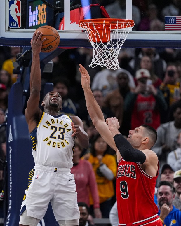Indiana Pacers guard Aaron Nesmith (23) hits a baskets over Chicago Bulls center Nikola Vucevic (9) in the closing seconds of the second half of an NBA basketball game in Indianapolis, Wednesday, Jan. 28, 2026. (AP Photo/Michael Conroy)