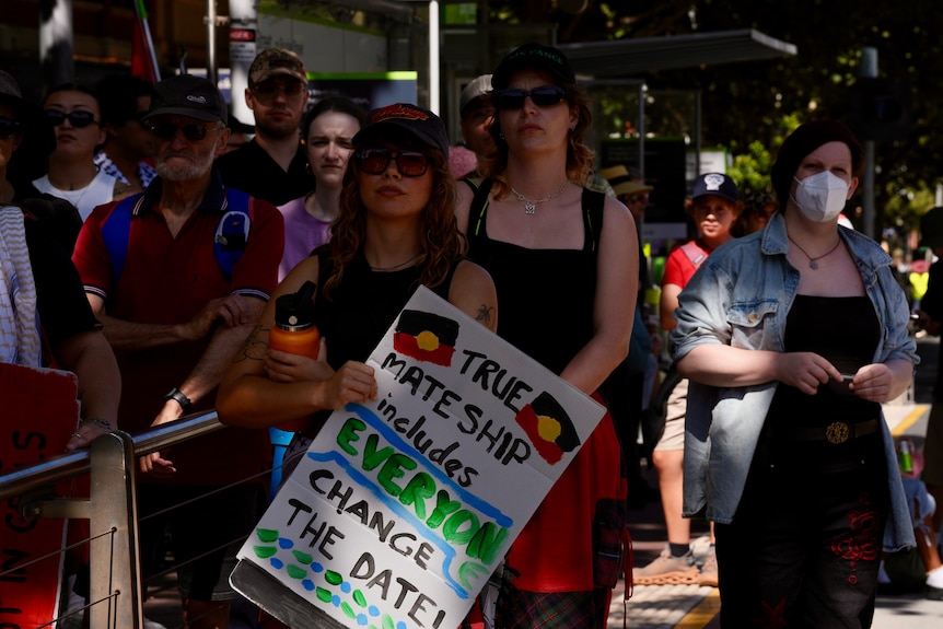 A group of people holding signs at a protest rally in Melbourne