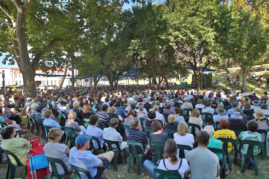 A large crowd sitting on deck chairs in a park watching a lecture at Adelaide Writers' Week