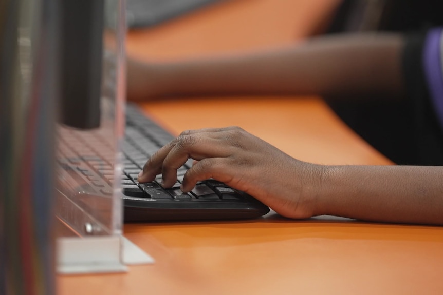 A hand rests on a keyboard