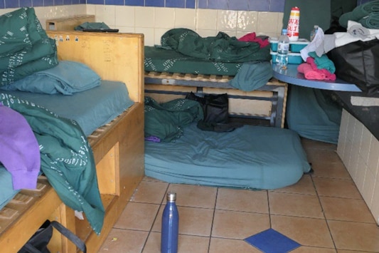 A mattress on the floor in a cell.