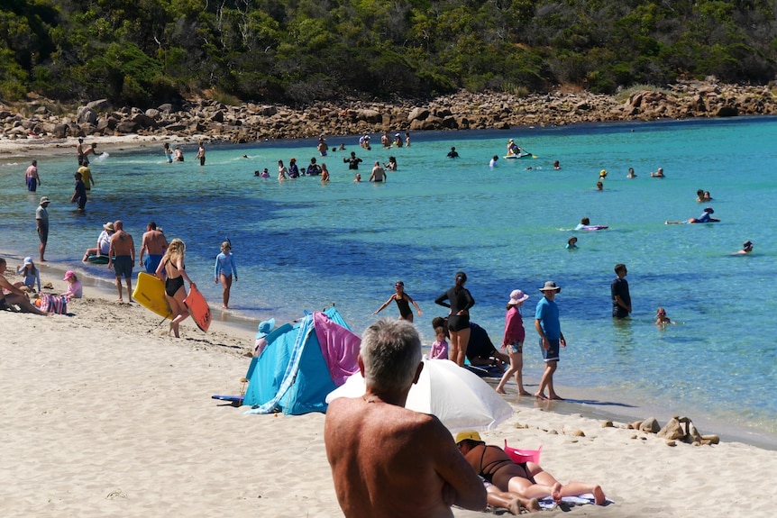 People swimming, laying on the beach and enjoying the beach