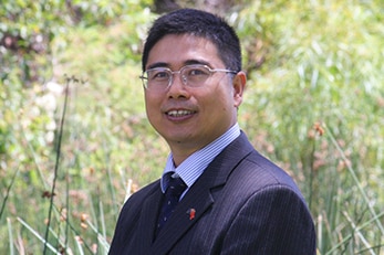 a man in suit facing camera and smiling