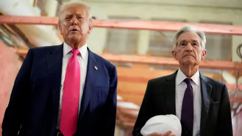 Reuters Donald Trump appears next to Jerome Powell, who is carrying a white hard hat, during a visit to the Federal Reserve building as it undergoes renovations.