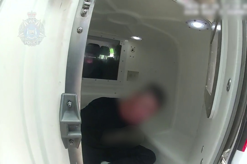 A man in the back of a police van