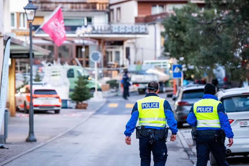 Police officers walk near the site of a fire that ripped through a bar in Crans-Montana, on January 1, 2026.
