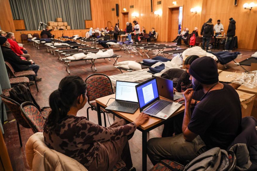Students work on their laptops at an aid station in Berlin's Steglitz-Zehlendorf district office on Monday.