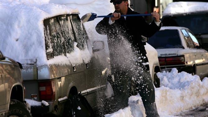 NEW YORK - FEBRUARY 13: A man clears snow from his vehicle the morning after a Northeast storm dropped more than two-feet of snow February 13, 2006 in New York City. The storm hit New York City on the night of February 11, 2006 resulting in blizzard conditions and setting a new snowfall record. The storm shut down airports in the Northeast and caused power outages.