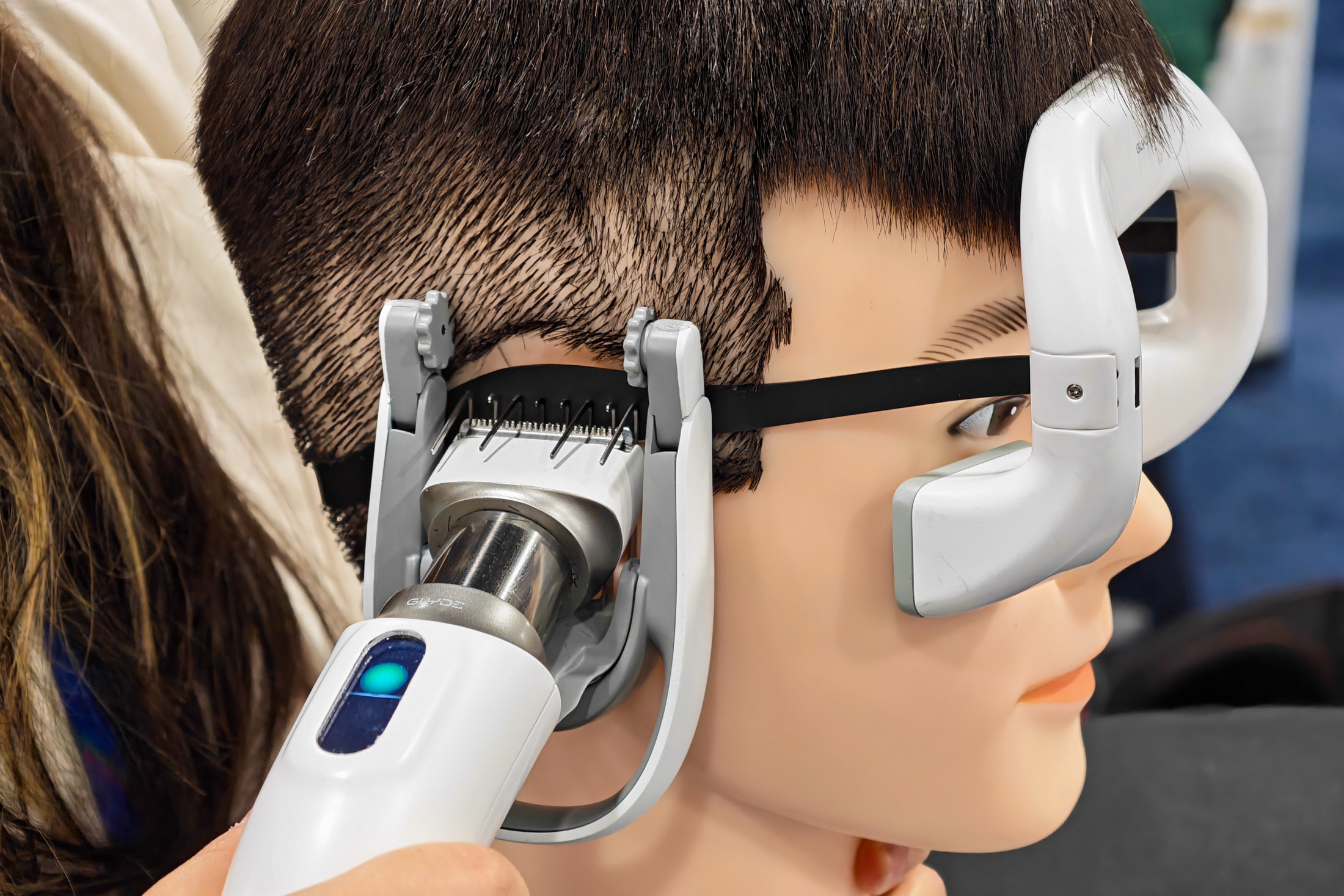 Photo of a mannequin head being “shaved” by the Glyde smart hair trimmer