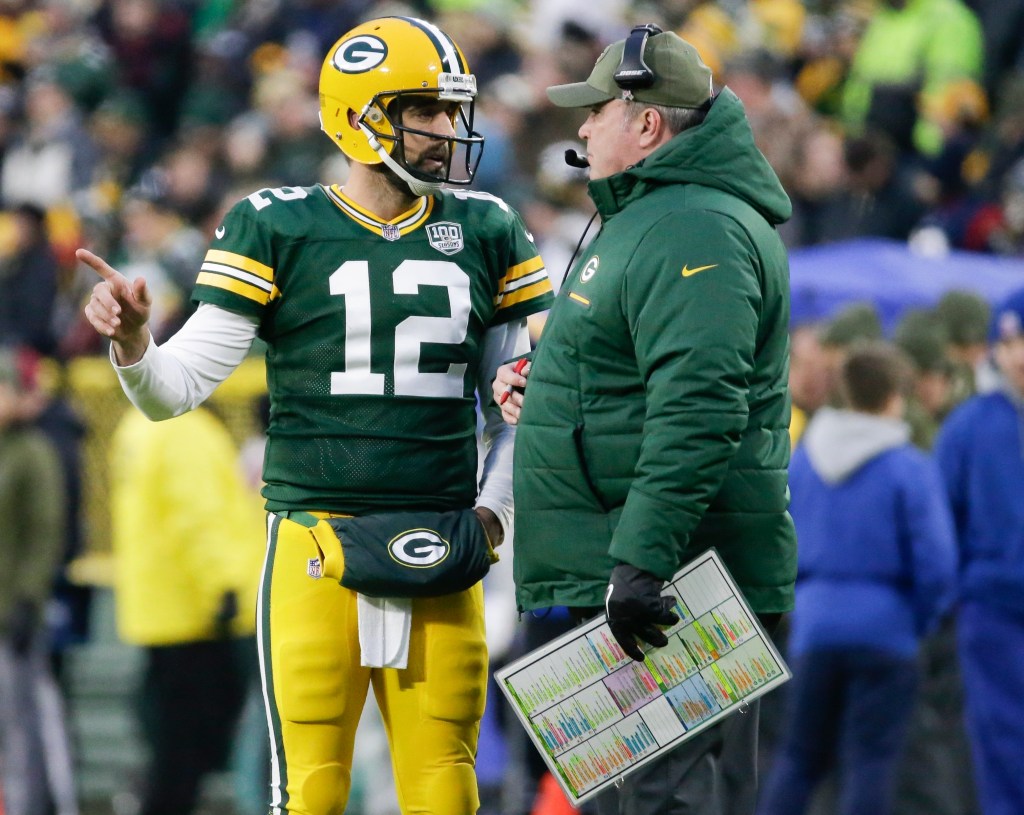 Green Bay Packers head coach Mike McCarthy talks to Aaron Rodgers during an NFL game.