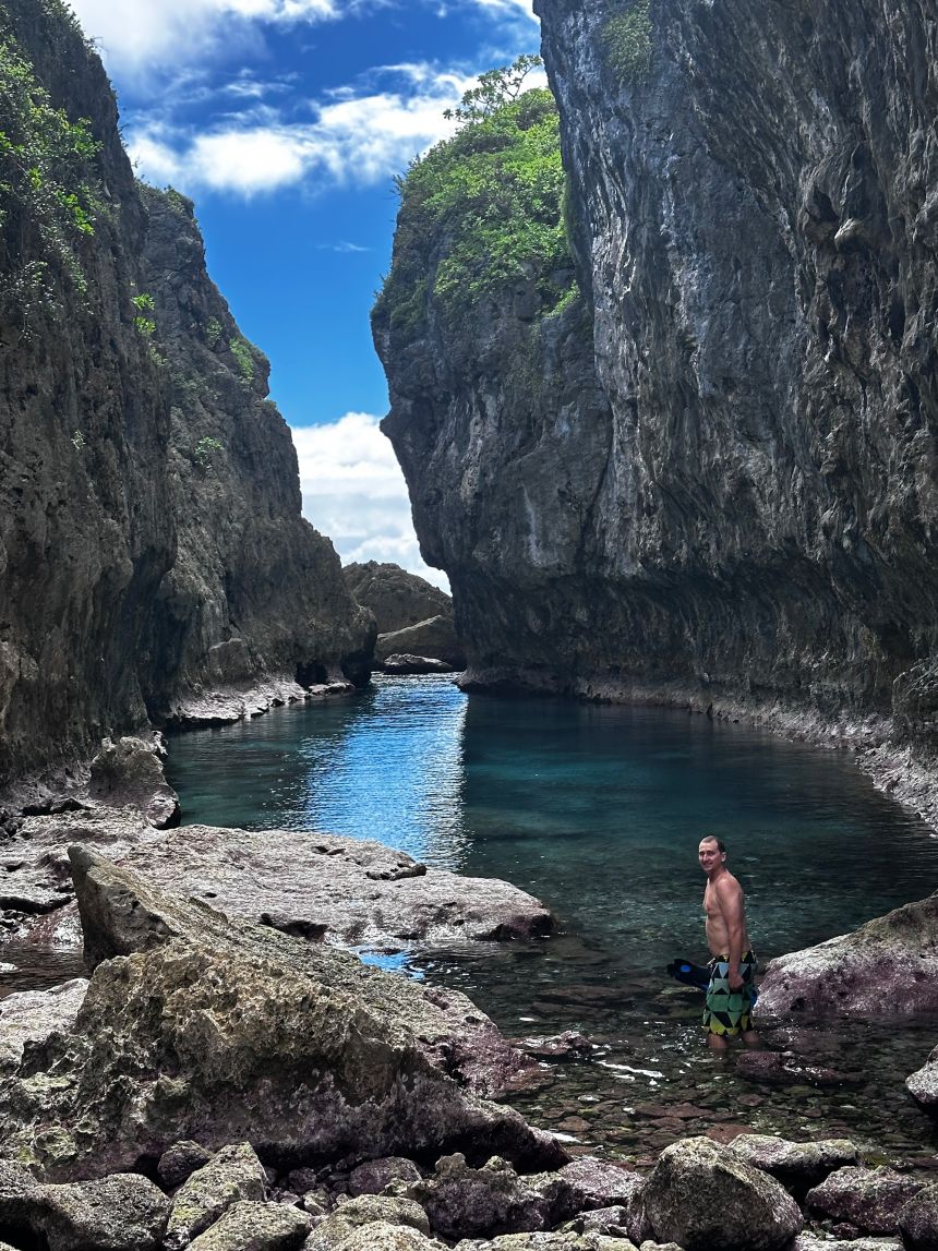 Jake stands in shallow water at Matapa Chasm on the island of Niue.