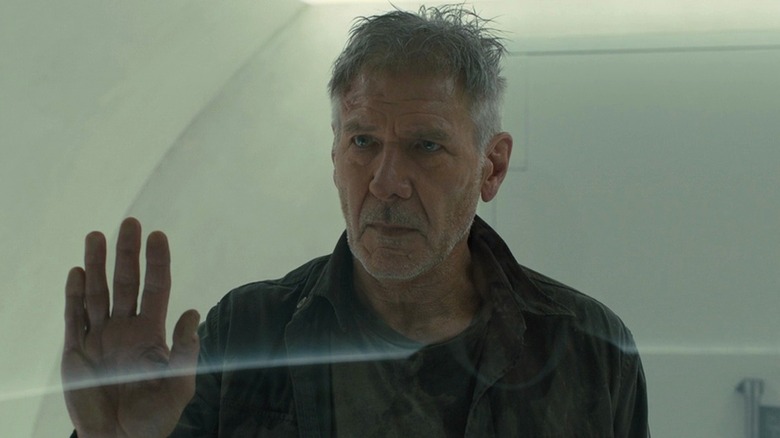 Rick Deckard holding hand up to glass sadly in 