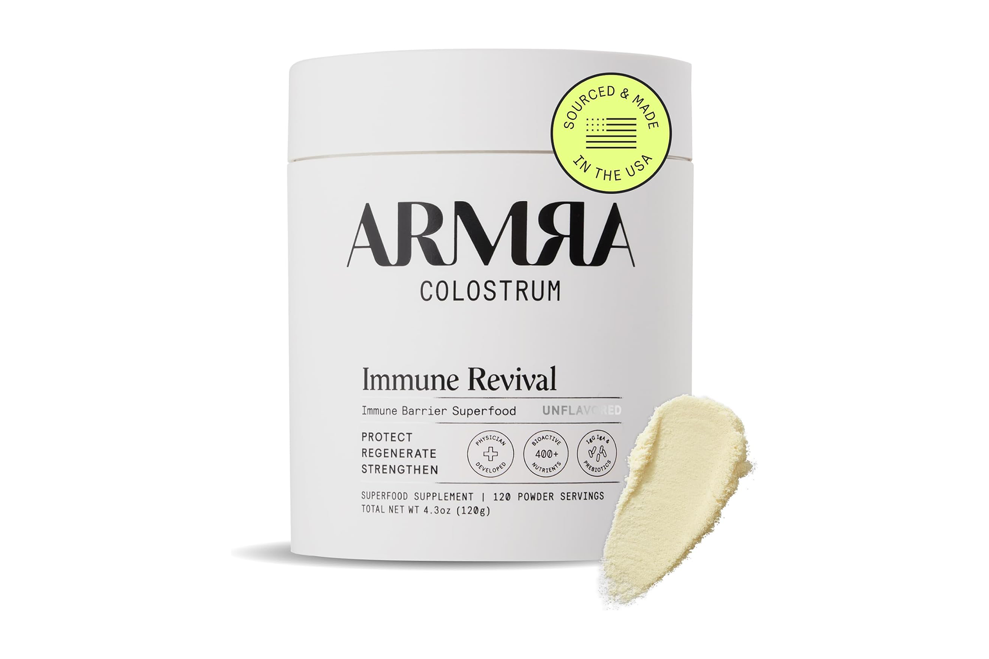 A white cylindrical container of Armra Colostrum Immune Revival superfood powder, with a small pile of the powder next to it.
