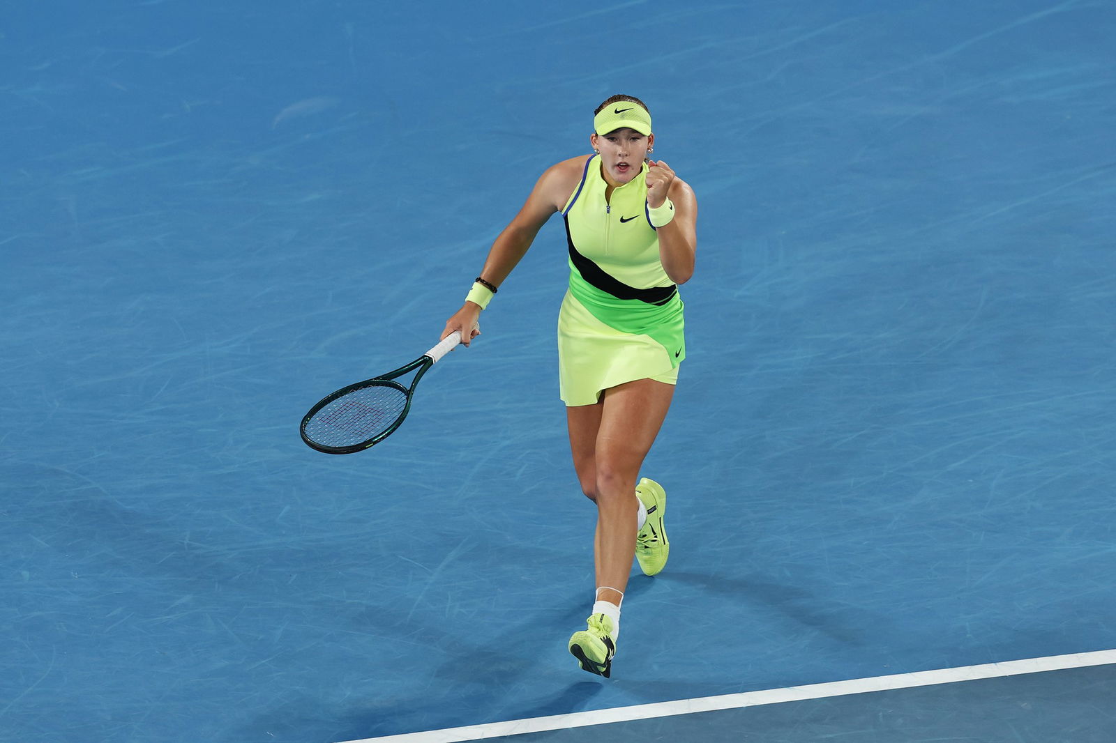 Mirra Andreeva gestures to the crowd while playing tennis