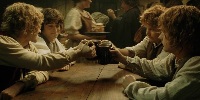 Sam (Sean Astin), Frodo (Elijah Wood), Pippin (Billy Boyd), and Merry (Dominic Monaghan) drinking together in The Lord of the Rings the Return of the King