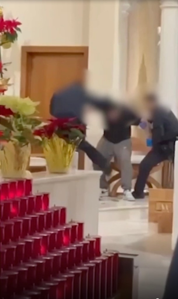 Man being arrested at an altar in a church, next to votive candles and flowers.