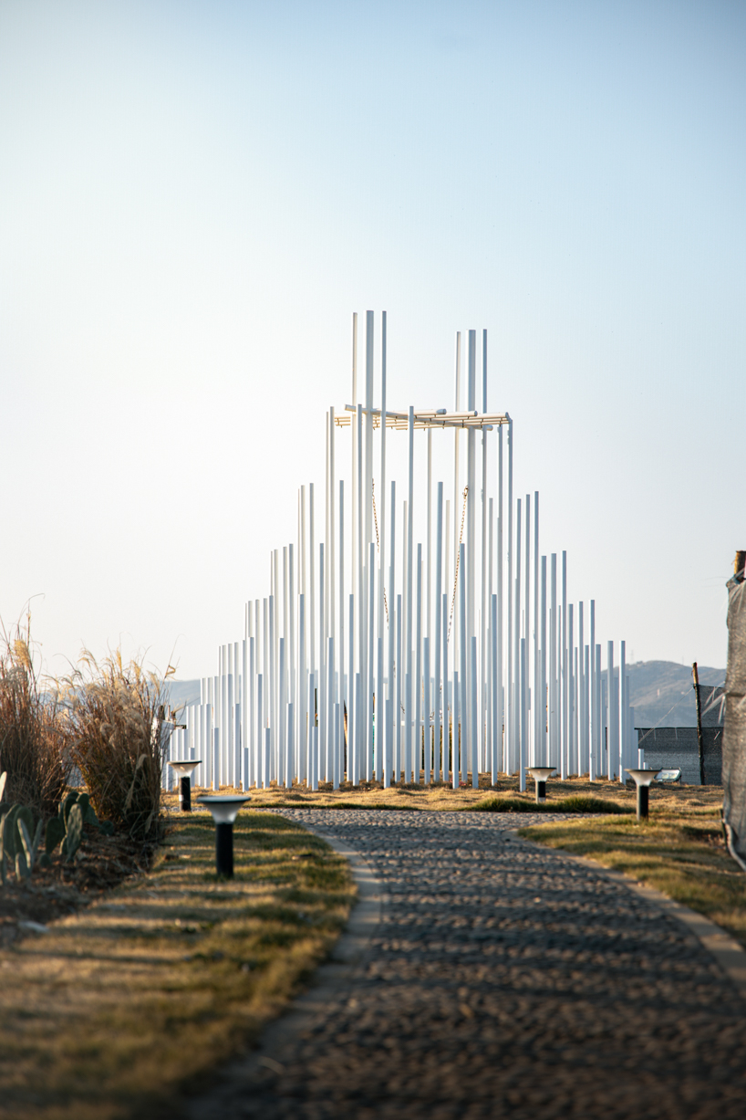 forest of steel pillars creates swinging installation enveloped in cloud-like mist in china