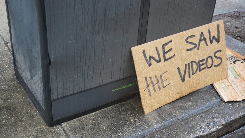 A sign on reads "We Save The Videos" outside the Federal Detention Center in Center City Philadelphia