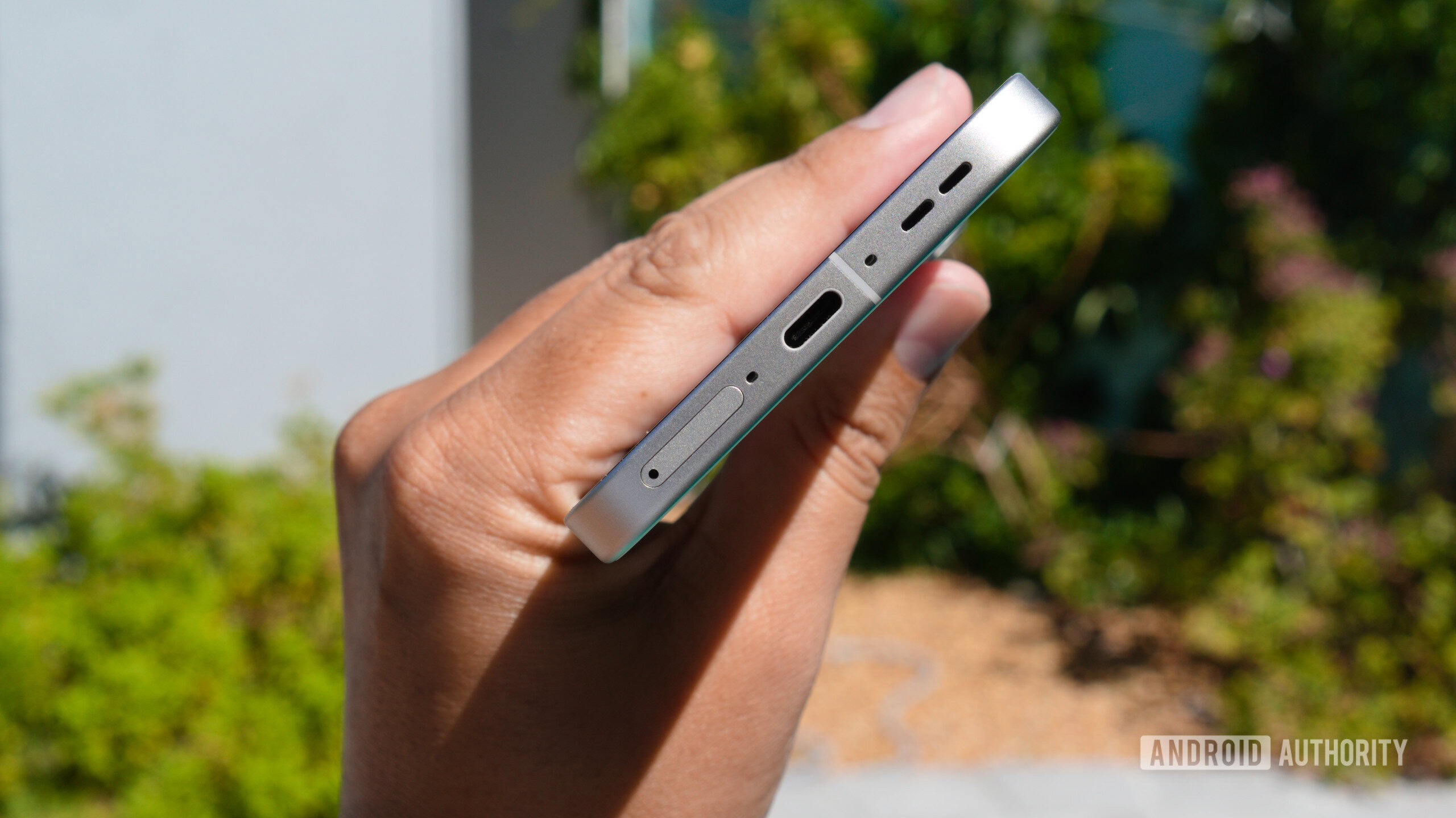 realme GT8 Pro in hand showing USB C port