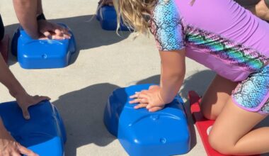 young person practices CPR on torso dummy